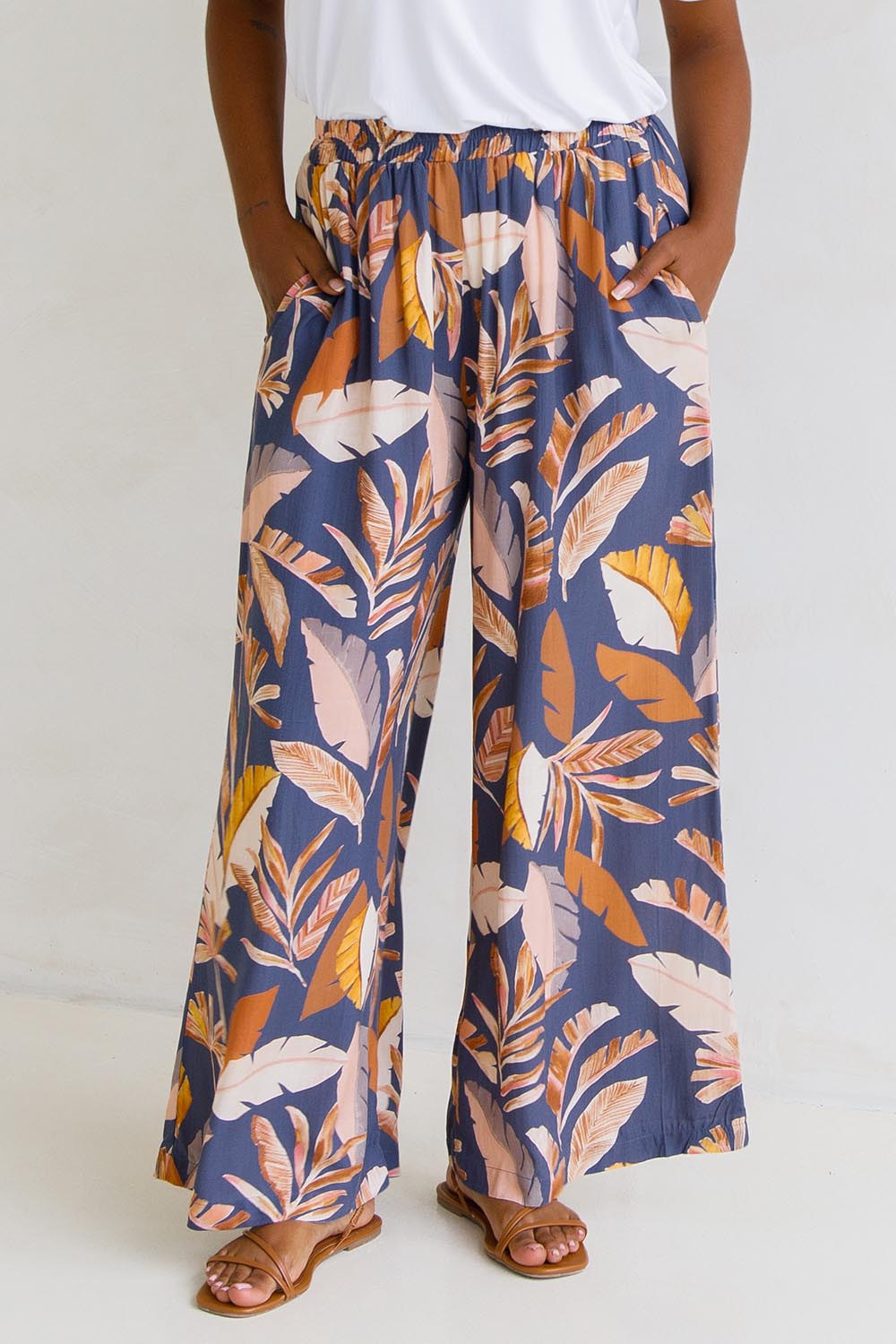 A model wearing the Aspen Pants in colour Darkpalme, from the front, cropped image