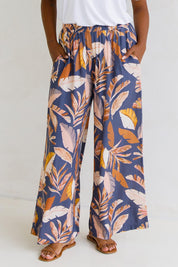 A model wearing the Aspen Pants in colour Darkpalme, from the front, cropped image