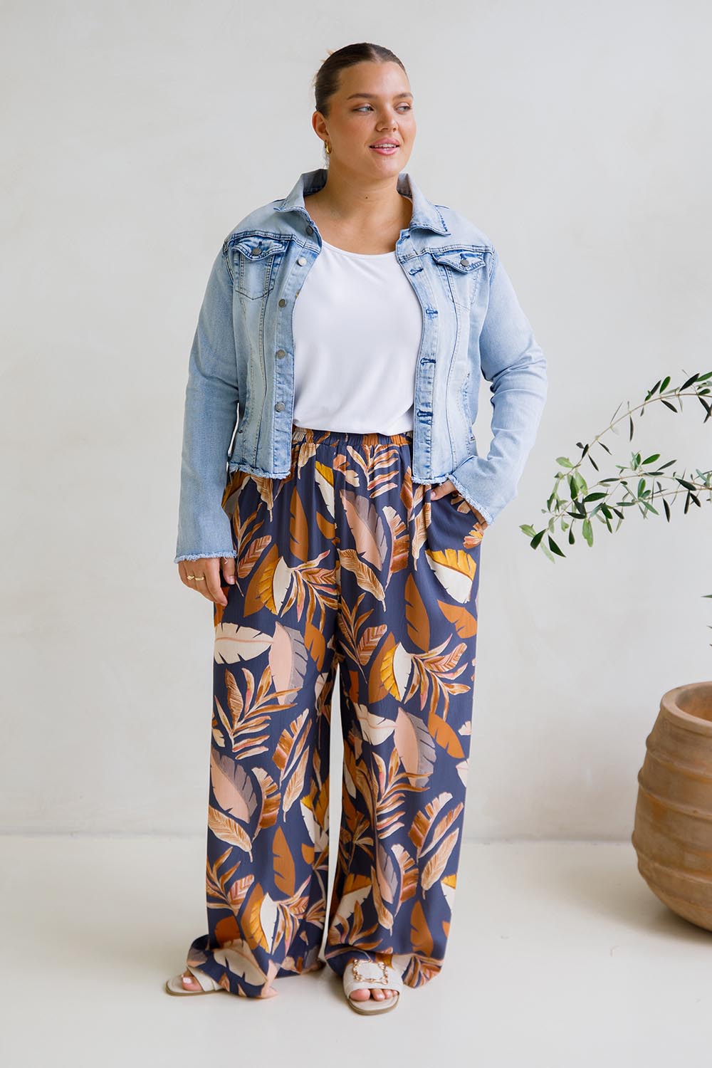 A model wearing the Aspen Pants in colour Darkpalme, from the front, showing the whole outfit