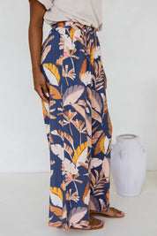 A model wearing the Aspen Pants in colour Darkpalme, from the front, showing the whole outfit