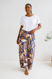 A model wearing the Aspen Pants in colour Darkpalme, from the front, showing the whole outfit