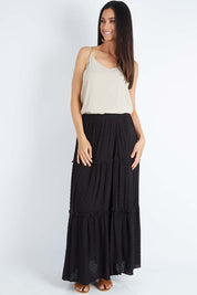 Model Gemma wearing size S of the Tier Maxi Skirt in colour Blackdot (Black), from the front, showing the whole outfit
