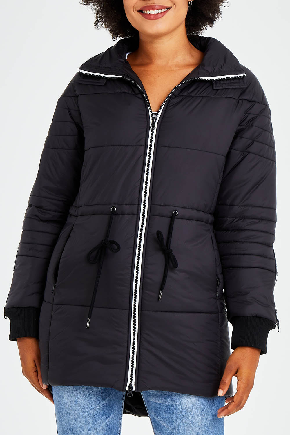 Model Olivia wearing size 10 of the Long Line Funnel Neck Puffer in colour Black (Black), from the front, cropped image