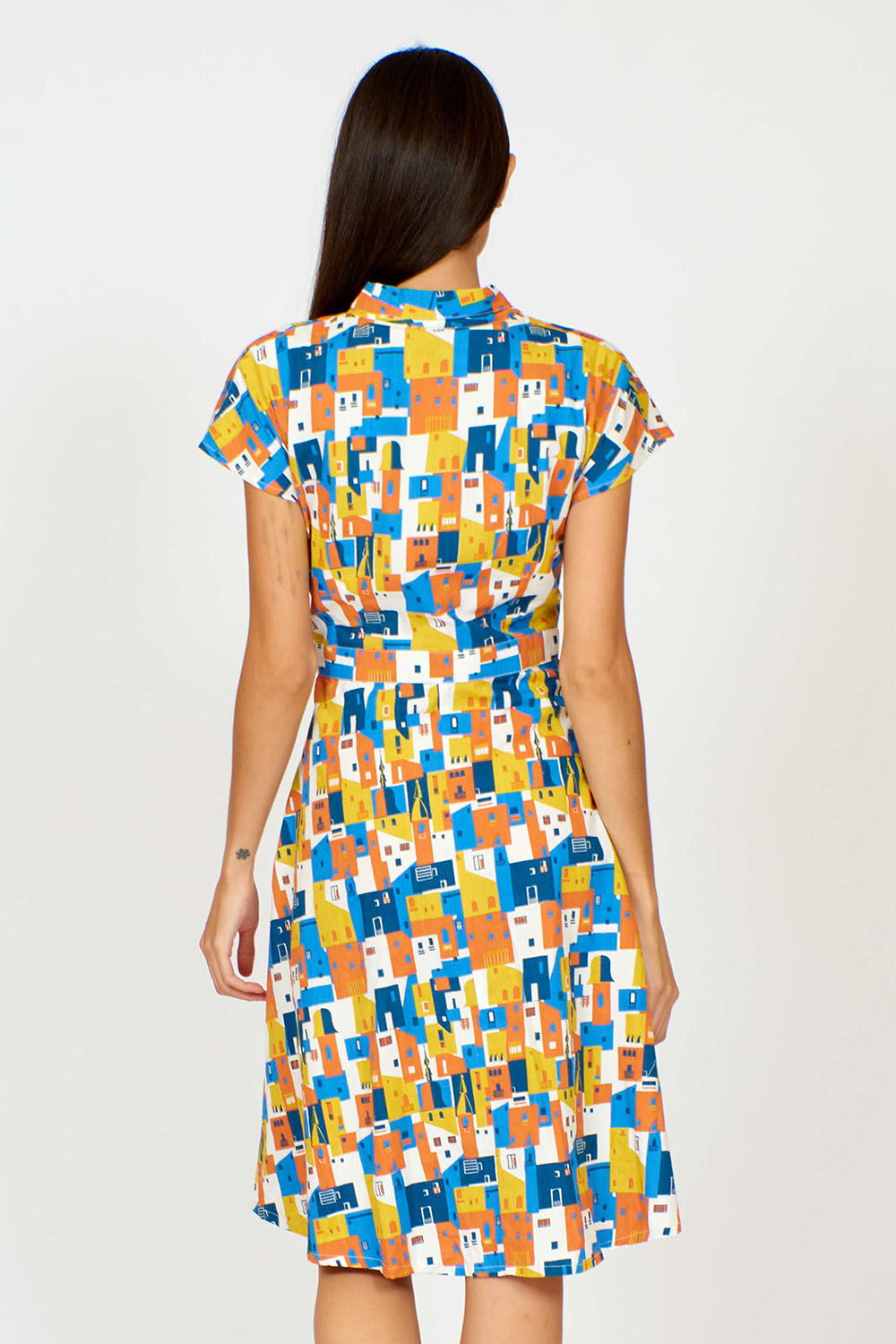 A model wearing the Kelly Dress in colour Houses (Blue), from the back