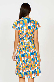 A model wearing the Kelly Dress in colour Houses (Blue), from the back