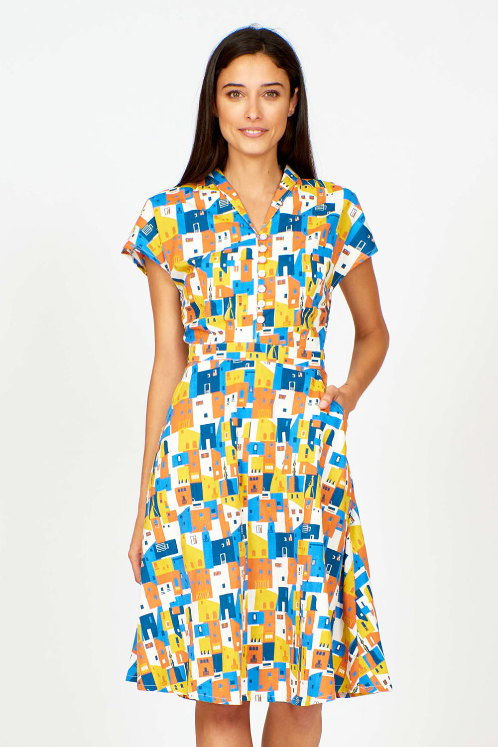 A model wearing the Kelly Dress in colour Houses (Blue), from the front, cropped image