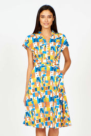 A model wearing the Kelly Dress in colour Houses (Blue), from the front, cropped image