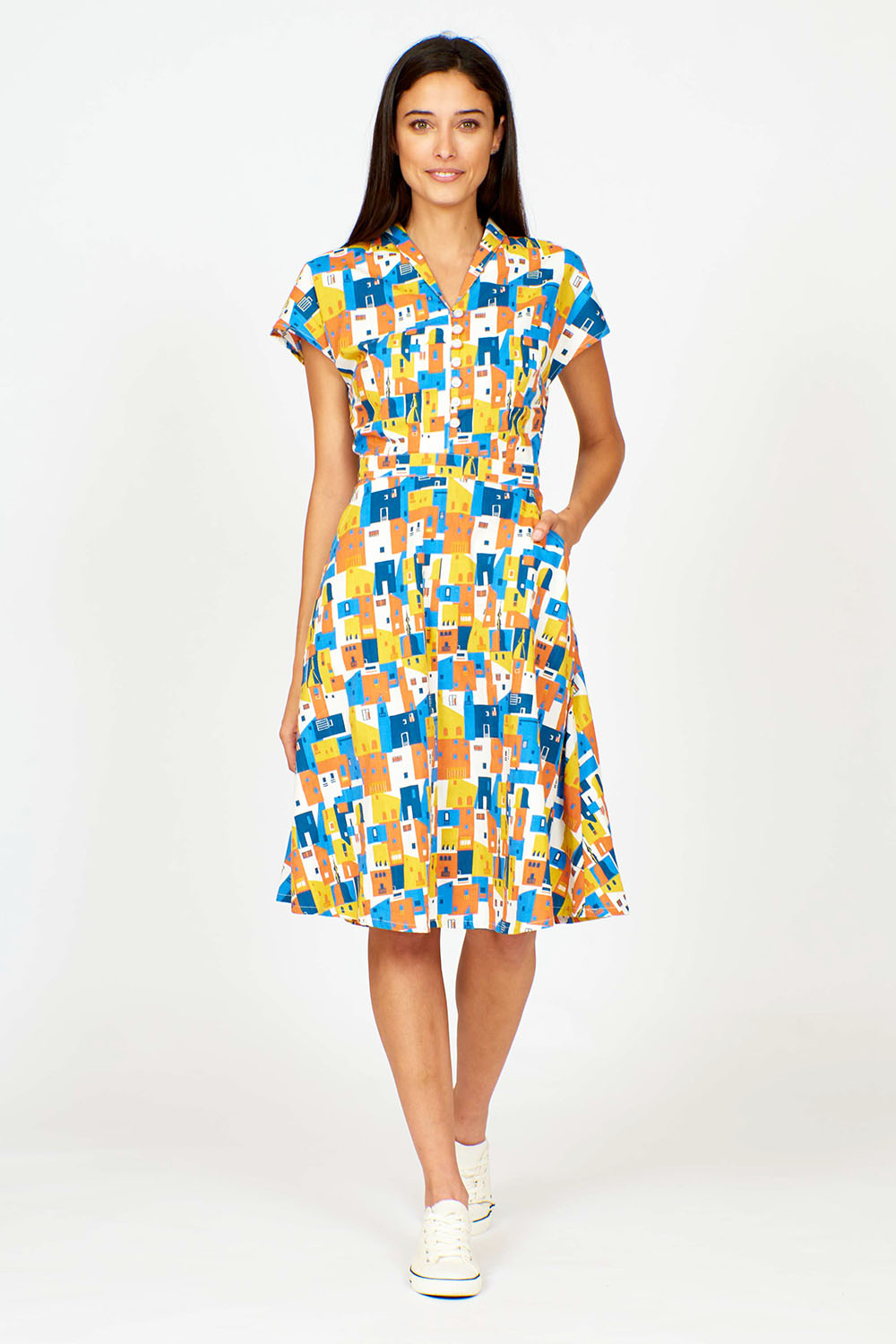 A model wearing the Kelly Dress in colour Houses (Blue), from the front, showing the whole outfit