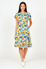A model wearing the Kelly Dress in colour Houses (Blue), from the front, showing the whole outfit