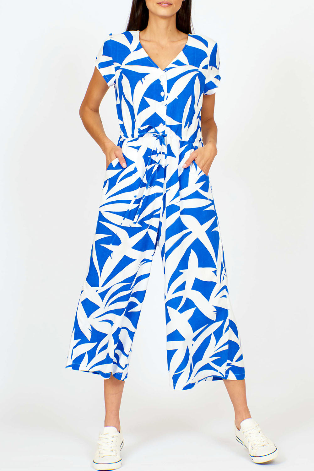 A model wearing the Fronds Playsuit in colour Fronds (Blue), from the front, cropped image