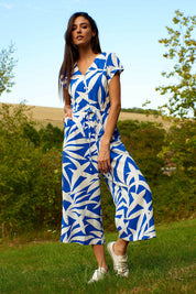 A model wearing the Fronds Playsuit in colour Fronds (Blue), from the front, showing the whole outfit