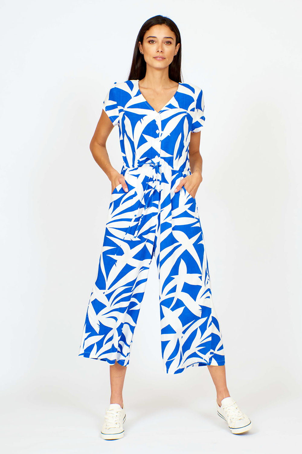 A model wearing the Fronds Playsuit in colour Fronds (Blue), from the front, showing the whole outfit