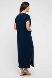 A model wearing the Elsie Dress in colour Navy (Blue), from the back