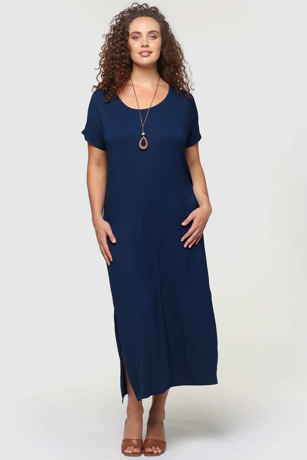 A model wearing the Elsie Dress in colour Navy (Blue), from the front, showing the whole outfit