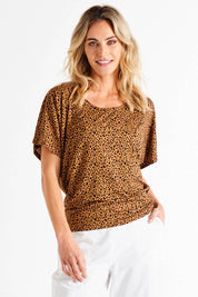 A model wearing the Maui Tee in colour Wildprint (Black), from the front, cropped image