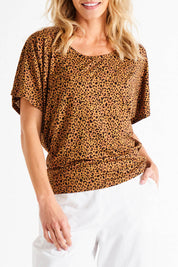 A model wearing the Maui Tee in colour Wildprint (Black), from the front, cropped image