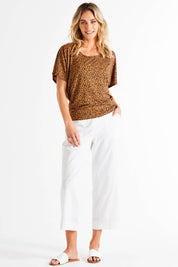 A model wearing the Maui Tee in colour Wildprint (Black), from the front, showing the whole outfit