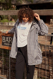 A model wearing the Rosie Raincoat in colour Navychequ (Blue), from the front, showing the whole outfit