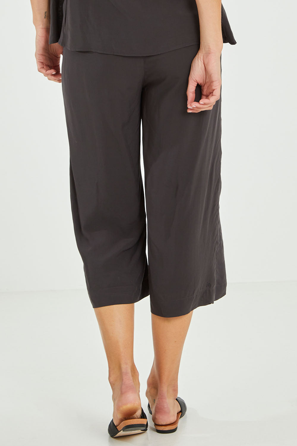 Model Alice wearing size 10 of the Alison Pant in colour Petrol (Black), from the back