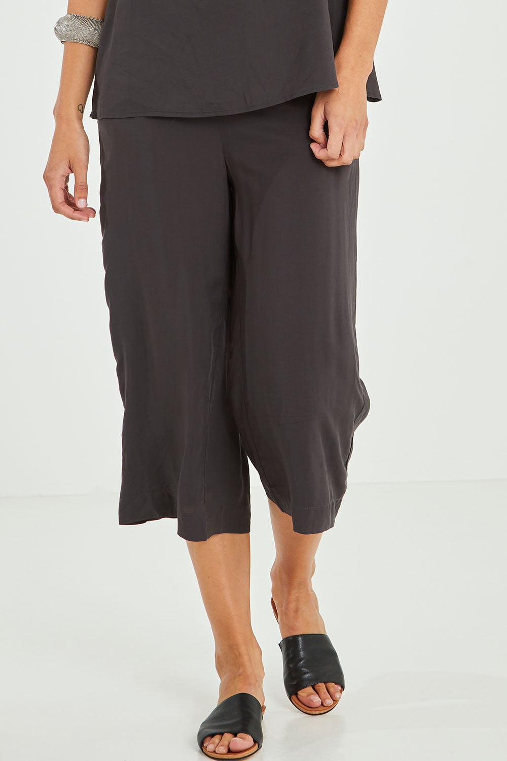 Model Alice wearing size 10 of the Alison Pant in colour Petrol (Black), from the front, cropped image