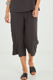 Model Alice wearing size 10 of the Alison Pant in colour Petrol (Black), from the front, cropped image