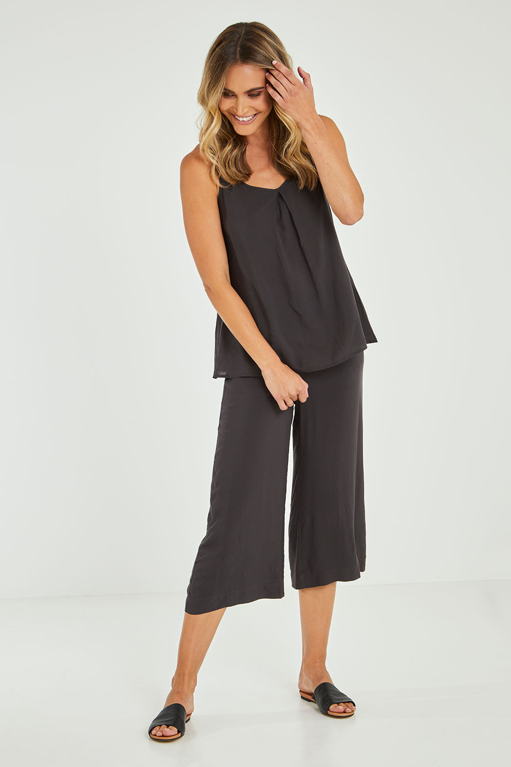 Model Alice wearing size 10 of the Alison Pant in colour Petrol (Black), from the front, showing the whole outfit