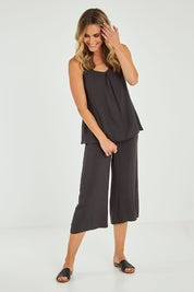 Model Alice wearing size 10 of the Alison Pant in colour Petrol (Black), from the front, showing the whole outfit