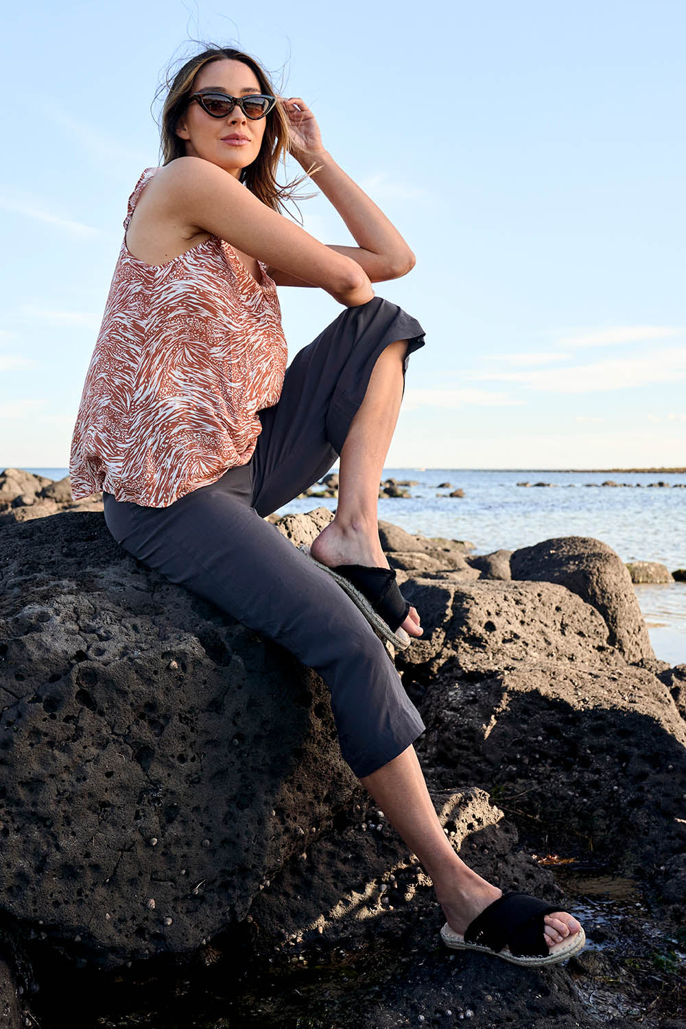A model wearing the Alison Pant in colour Petrol (Black), from the front, showing the whole outfit