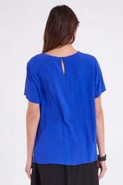 Model Madeline wearing size 10 of the Sangria Top in colour Decoblue (Blue), from the back