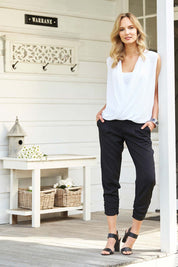 Model Alex wearing size 8 of The Best Seller Pant in colour JetBlack (Black), from the front, showing the whole outfit