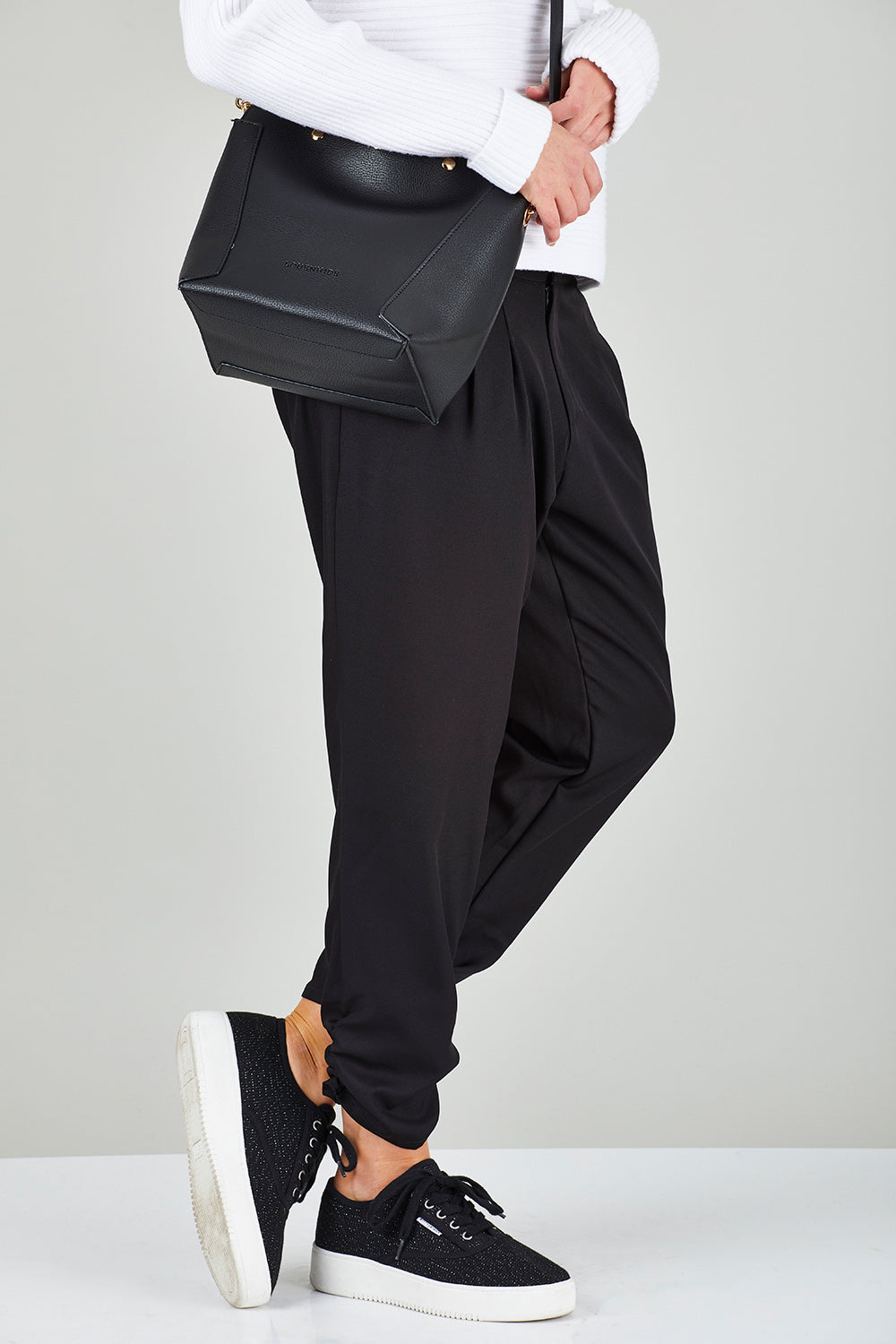 Model Chelsea wearing size 10 of The Best Seller Pant in colour JetBlack (Black), from the front, cropped image