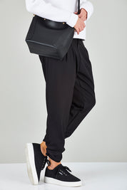 Model Chelsea wearing size 10 of The Best Seller Pant in colour JetBlack (Black), from the front, cropped image
