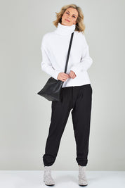 Model Chelsea wearing size 10 of The Best Seller Pant in colour JetBlack (Black), from the front, showing the whole outfit
