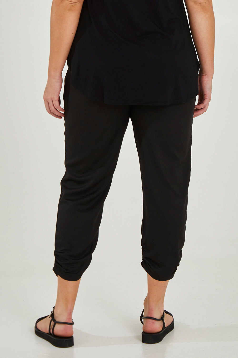 Model Maddy wearing size 16 of The Best Seller Pant in colour JetBlack (Black), from the back