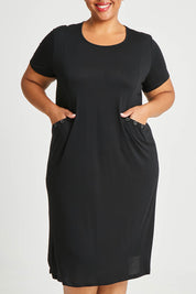 Model Alexis wearing size 16 of The Bamboo Blend Button Dress in colour Black (Black), from the front, cropped image