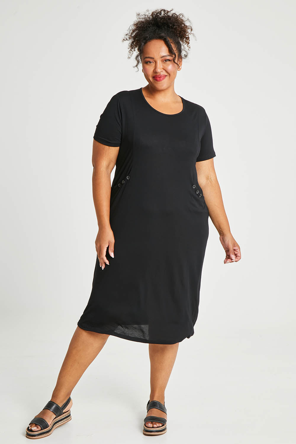 Model Alexis wearing size 16 of The Bamboo Blend Button Dress in colour Black (Black), from the front, showing the whole outfit