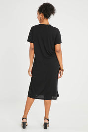 Model Noli wearing size 14 of The Bamboo Blend Button Dress in colour Black (Black), from the back