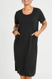 Model Noli wearing size 14 of The Bamboo Blend Button Dress in colour Black (Black), from the front, cropped image