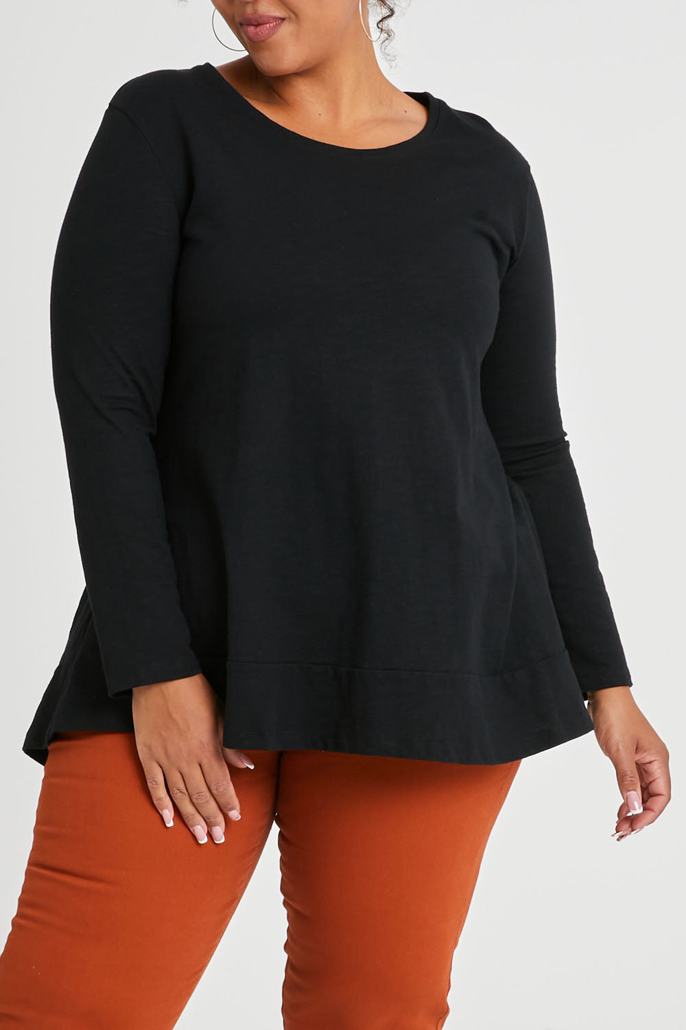 Model Alexis wearing size 16 of The Long Sleeve Swing Tee in colour Black (Black), from the front, cropped image