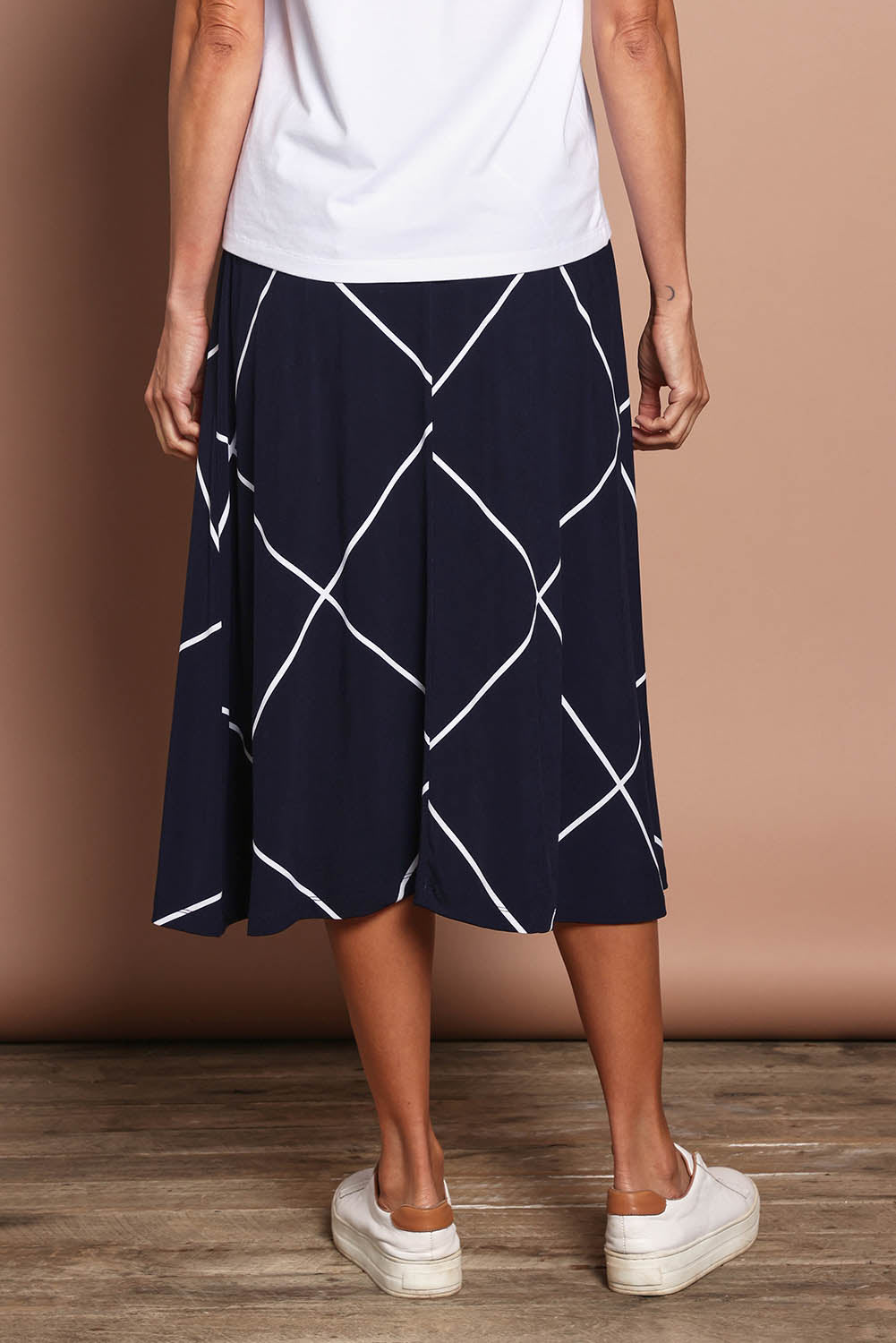 Model Amanda wearing size 10 of The Pull On Skirt in colour Navywhite (Blue), from the back