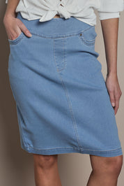 Model Madeline wearing size 10 of The Pull On Denim Skirt in colour Lightdenim (Blue), from the front, cropped image