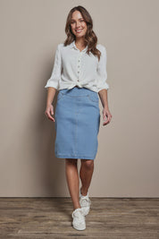 Model Madeline wearing size 10 of The Pull On Denim Skirt in colour Lightdenim (Blue), from the front, showing the whole outfit