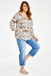 Model Laura wearing size 14 of The V Neck Printed Top in colour Peachprint (White), from the front, showing the whole outfit