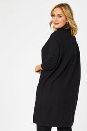 Model Jess wearing size L of The Cable Knit Dress in colour Blackfleck (Black), from the back