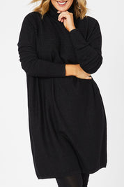 Model Jess wearing size L of The Cable Knit Dress in colour Blackfleck (Black), from the front, cropped image