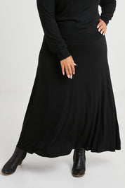 Model Alexis wearing size 16 of The Best Seller Skirt in colour JetBlack (Black), from the front, cropped image