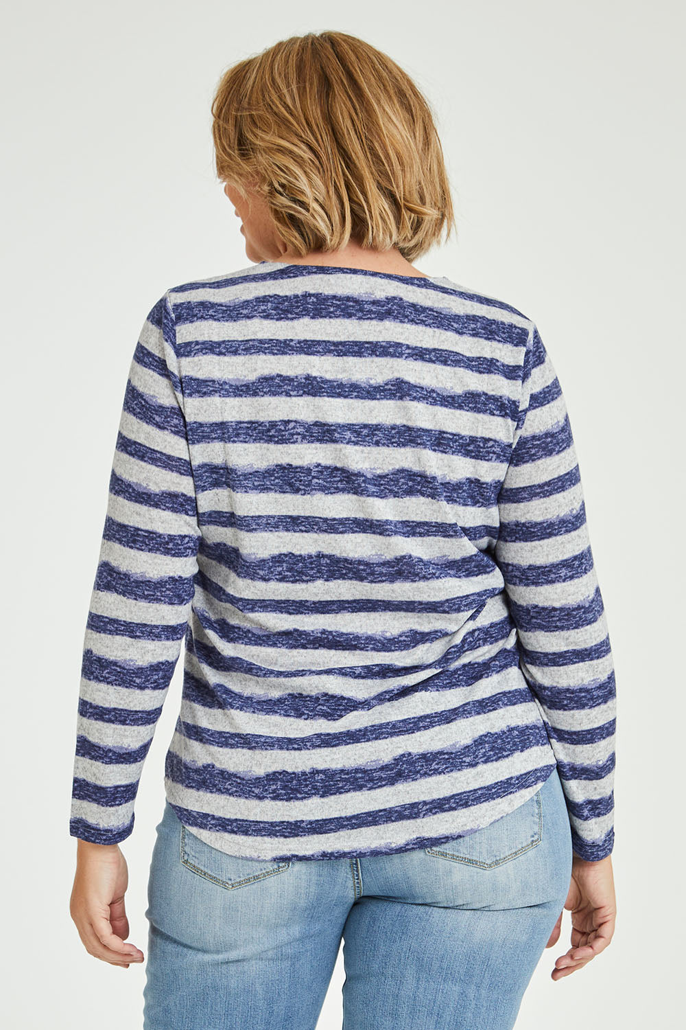 Model Fiona wearing size 16 of The Striped Curved Hem Long Sleeve Tee in colour Cornflower (Blue), from the back