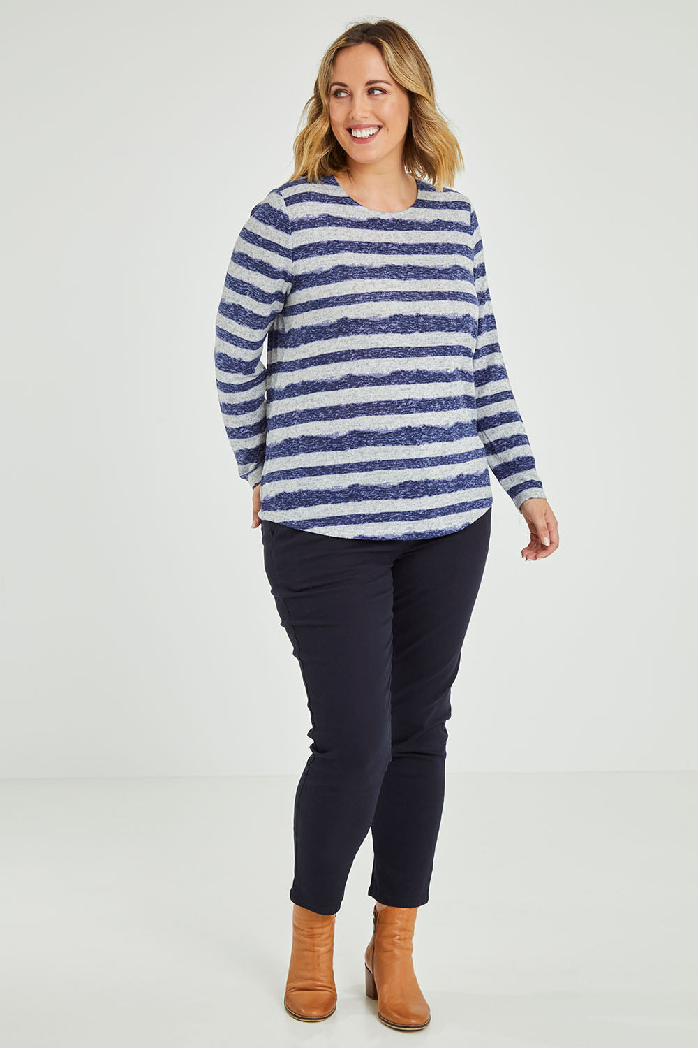 Model Jess wearing size 14 of The Striped Curved Hem Long Sleeve Tee in colour Cornflower (Blue), from the front, showing the whole outfit