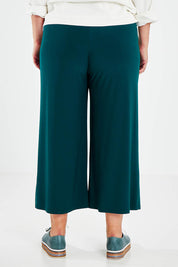Model Jess wearing size 14 of The Recycled Relax Fit Pant in colour Deeplagoon (Green), from the back