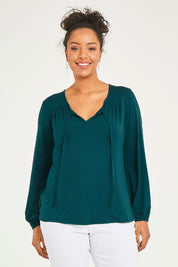 Model Terri-Leigh wearing size 14 of the Preloved The V Neck Tie Top in colour Juniper (Green), from the front, cropped image